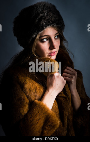 Une jeune femme, portant un manteau de fourrure et chapeau, froid, des vêtements d'hiver, Banque D'Images