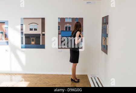 Une femme à la recherche de tableaux à la fin d'exposition à Aberystwyth University School of Art, le Pays de Galles UK Banque D'Images