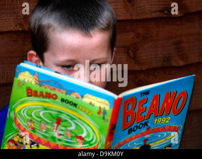 La lecture d'un jeune garçon Beano Comic annuelle. Banque D'Images