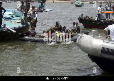 Les responsables de sauvetage occupés dans d'opération de recherche après un chavirement de bateau en mer près de port Keamari à Karachi le vendredi, Juin 21, 2013. Le bateau transportait les habitants et les touristes de Keamari zone à Lèvres Island lorsqu'il s'est noyé. Les responsables ont dit que le sauvetage bateau a coulé à cause de la surcharge qu'elle avait la capacité de chargement de 30 personnes mais il transportait plus de 50 personnes. Au moins 15 personnes ont disparu quand un bateau a chaviré au large de la mer d'Arabie du sud du Pakistan, près de la ville portuaire de Karachi. Banque D'Images