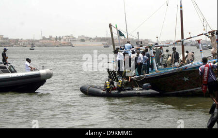 Les responsables de sauvetage occupés dans d'opération de recherche après un chavirement de bateau en mer près de port Keamari à Karachi le vendredi, Juin 21, 2013. Le bateau transportait les habitants et les touristes de Keamari zone à Lèvres Island lorsqu'il s'est noyé. Les responsables ont dit que le sauvetage bateau a coulé à cause de la surcharge qu'elle avait la capacité de chargement de 30 personnes mais il transportait plus de 50 personnes. Au moins 15 personnes ont disparu quand un bateau a chaviré au large de la mer d'Arabie du sud du Pakistan, près de la ville portuaire de Karachi. Banque D'Images