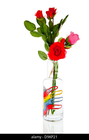 Vase en verre avec des marionnettes à doigt rempli de rouges et roses roses artificielles Banque D'Images