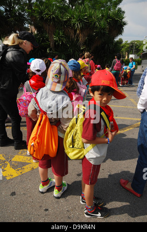 Groupe d'enfants et leurs compagnons sur leur chemin au Parc Guell Barcelone Espagne Banque D'Images