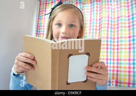 Portrait of young girl reading book Banque D'Images