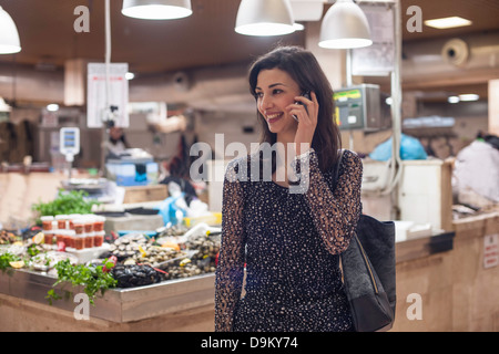 Woman on cell phone in fish market Banque D'Images