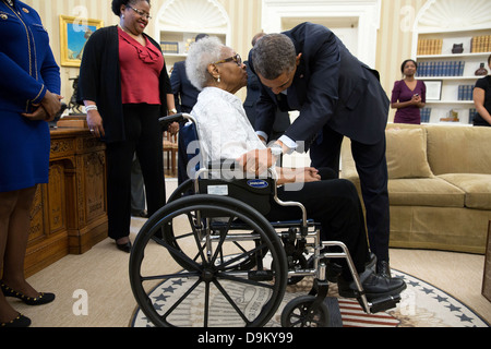 Le président américain Barack Obama parle avec Thelma Maxine Pippen McNair, mère de Denise McNair, après la signature d'H.R. 360 dans le bureau ovale le 24 mai 2013 à Washington, DC. La loi prévoit la présentation d'une médaille d'or du congrès américain pour commémorer la vie des quatre jeunes Américains africains victimes de l'attentat de la seizième Street Baptist Church à Birmingham, Alabama, en septembre 1963. Banque D'Images