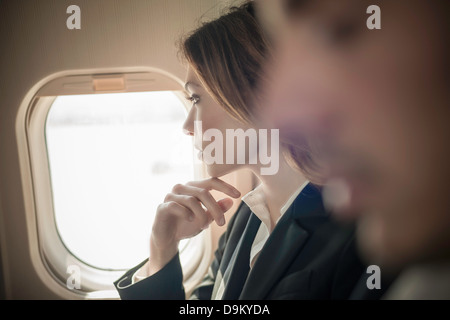 Passagère à la fenêtre de l'avion de Banque D'Images