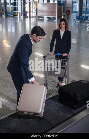 En affaires dans la zone de récupération des bagages de l'aéroport Banque D'Images