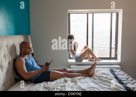 Young couple relaxing in bedroom Banque D'Images