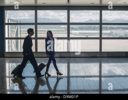 Businesspeople walking in airport Banque D'Images