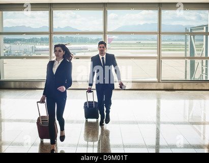 Businesspeople running in airport Banque D'Images