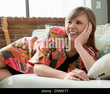 Young woman relaxing on sofa Banque D'Images