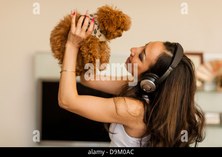 Mid adult woman wearing headphones et danse avec chien Banque D'Images