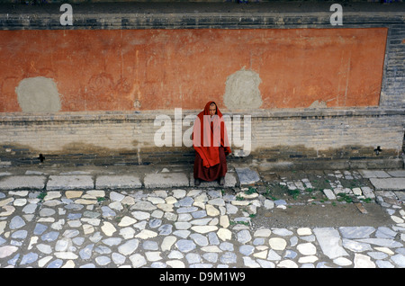 Un moine bouddhiste Bhikkhu dans le Gompa tibétain du monastère appelé aussi Temple Ta'er fondée en 1583 dans une vallée étroite à proximité du village de Lusar dans la région tibétaine de l'Amdo historique à Huangzhong County, à Xining la capitale de la province de Qinghai en Chine occidentale Banque D'Images