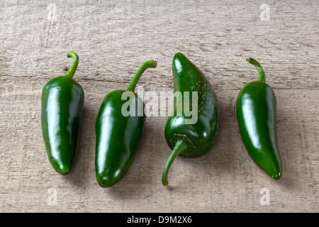 Piments Jalapeno vert piments jalapeno - quatre sur une planche ou un fond rustique. Banque D'Images