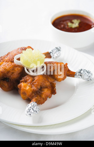 Sucette de poulet servi dans une assiette Banque D'Images