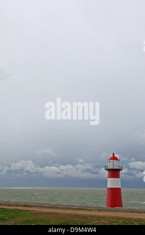 Leuchtturm en Zélande (Pays-Bas) avec la mer du Nord et nuages dans le ciel blanc Banque D'Images