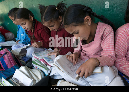 Les écoliers indiens lire en dehors de leur classe dans le district tribal de Bharmour, Himachal Pradesh, Inde Banque D'Images