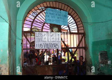 La Paz, Bolivie. 22 juin 2013. Affiches sur la porte principale la prison exigent la démission du chef de l'administration pénitentiaire Ramiro Llanos pour de prétendus actes de corruption (en haut) et d'annoncer que les détenus répudier les violeurs (en bas). Les autorités boliviennes ont récemment annoncé que l'intention de fermer la prison serait avancée au 18 juillet après des allégations qu'une jeune fille de 12 ans qui n'a pas d'autre choix que de vivre dans la prison est tombée enceinte après avoir été violée à plusieurs reprises par son père et les autres hommes de leur famille qui sont détenus... (....Suite dans la description) Banque D'Images