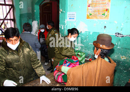 La Paz, Bolivie. 22 juin 2013. Une femme aymara ou cholita a ses affaires fouillés par la police avant de visiter des proches emprisonnés dans la prison de San Pedro. Banque D'Images