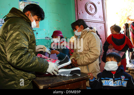 La Paz, Bolivie. 22 juin 2013. Une femme et son fils ont leurs effets personnels fouillés par la police avant de visiter des proches emprisonnés dans la prison de San Pedro. Banque D'Images