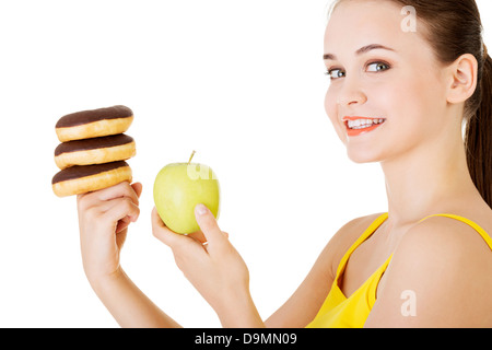 Donut ou pomme verte - choix difficile. Concept de régime. Banque D'Images