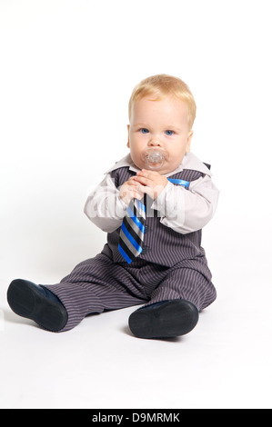 Blond bébé avec tétine en costume avec cravate officielle Banque D'Images