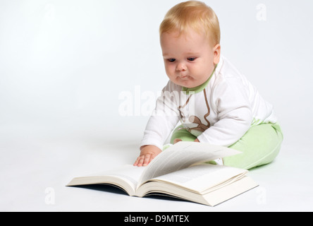 Baby-sitting blonde intelligente et la lecture d'un livre Banque D'Images