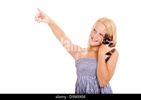 Belle teen girl holding animal chaton et pointant sur copyspace Banque D'Images