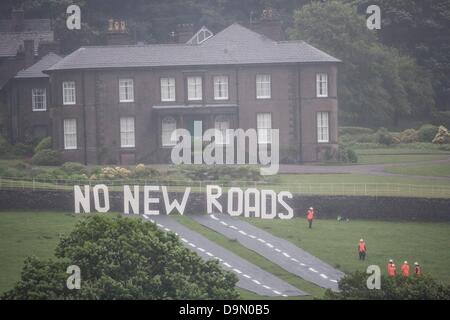 Cheshire, Royaume-Uni. 23 juin 2013. 20 militants vêtus de roadbuilders' high viz vêtements et casques de déployer une fausse route dans le champ juste au-dessous de Crag, Cheshire Hall dans les motifs qui le chancelier de l'echiquier George Osborne a une résidence . La protestation a été faite pour mettre en évidence la libération prévue de l'argent pour des programmes de construction de routes dans tout le Royaume-Uni dans les dépenses reivew imminente le mercredi 26 juin Crédit : Adrian arbib/Alamy Live News Banque D'Images