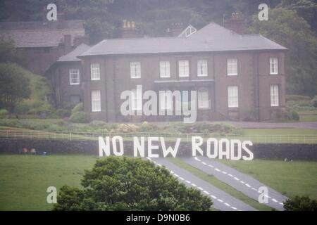 Cheshire, Royaume-Uni. 23 juin 2013. 20 militants vêtus de roadbuilders' high viz vêtements et casques de déployer une fausse route dans le champ juste au-dessous de Crag Hall, dans le Cheshire dont les motifs, le Chancelier de l'echiquier George Osborne a une résidence. La protestation a été faite pour mettre en évidence la libération prévue de l'argent pour des programmes de construction de routes dans tout le Royaume-Uni dans les dépenses reivew imminente le mercredi 26 juin Crédit : Adrian arbib/Alamy Live News Banque D'Images