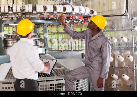 Gestionnaire d'usine de textile et le tissage de fils de contrôle ouvrier sur machine Banque D'Images