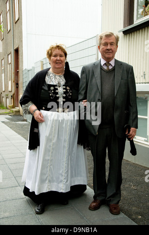 La Journée nationale de l'Islande sur un couple d'âge moyen--la femme portant le costume national complet--marcher dans une rue Reyjkavik Banque D'Images