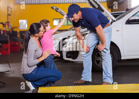 Cute little girl Playing with auto mechanic in garage Banque D'Images