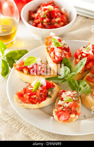 Bruschetta Tomate et basilic fait maison avec de l'huile d'olive sur du pain grillé Banque D'Images