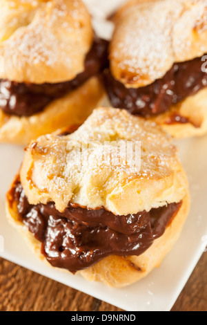 Profiteroles au chocolat maison contre un arrière-plan Banque D'Images