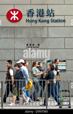 Passants à la station de métro Gare de Hong Kong, le logo de la station de métro MTR de Hong Kong, Hong Kong Banque D'Images