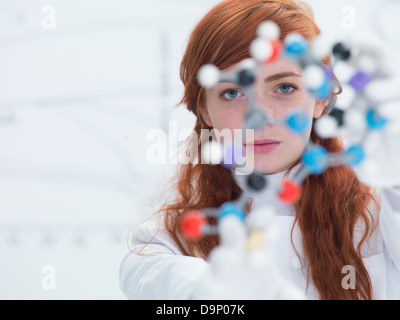Macro d'une élève dans un laboratoire de chimie tenant dans les mains et l'analyse de modèle moléculaire DMT Banque D'Images
