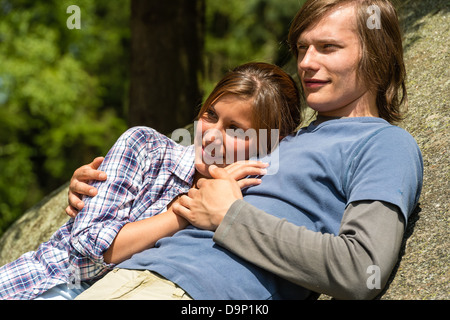 Young Caucasian couple soleil couché sur rock Banque D'Images