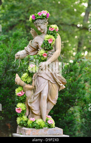 Old Westbury, New York, États-Unis 22 juin 2013. Diane chasseresse avec son chien de chasse est l'une des nombreuses statues décorées avec des guirlandes de fleurs et de guirlandes à l'événement Une nuit d'été à Old Westbury Gardens, sur la base de l'historique de l'île Long La Côte d'or immobilier. Credit : Ann E Parry/Alamy Live News Banque D'Images