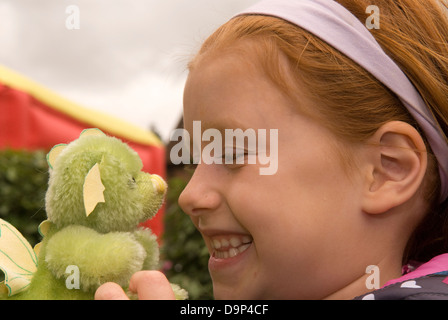 6 ans, fille d'un dragon vert fait main à un ours festival, Alton, Hampshire, Royaume-Uni. Banque D'Images