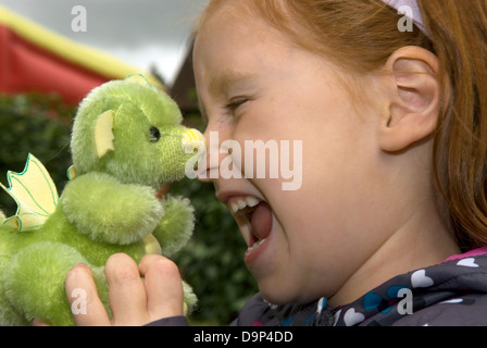 6 ans, fille d'un dragon vert fait main à un ours festival, Alton, Hampshire, Royaume-Uni. Banque D'Images