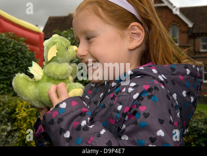 6 ans, fille d'un dragon vert fait main à un ours festival, Alton, Hampshire, Royaume-Uni. Banque D'Images