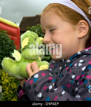 6 ans, fille d'un dragon vert fait main à un ours festival, Alton, Hampshire, Royaume-Uni. Banque D'Images