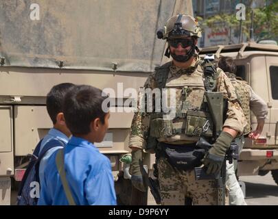 Un soldat de la Bundeswehr (armée allemande) sourit, tandis que deux jeunes Afghans passer devant lui à Mazar-i-Sharif, Afghanistan, Allemagne, 09 juin 2013. Photo : Nicolas Armer Banque D'Images