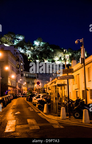 Une petite rue avec des voitures en stationnement à côté de la Promenade des Anglais dans la vieille ville de Nice France dans la nuit avec la colline du Château Banque D'Images