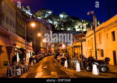 Une petite rue avec des voitures en stationnement à côté de la Promenade des Anglais dans la vieille ville de Nice France dans la nuit avec la colline du Château Banque D'Images