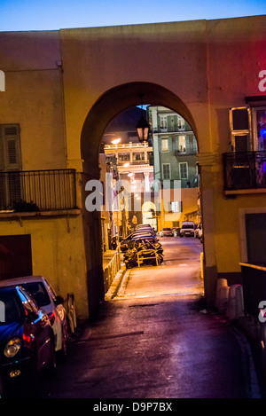 Une petite rue avec des voitures en stationnement à côté de la Promenade des Anglais dans la vieille ville de Nice France la nuit Banque D'Images