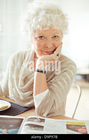 Portrait of a senior woman looking at you with hand on chin Banque D'Images