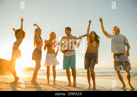 Groupe d'amis ayant une fête sur la plage Banque D'Images